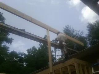 Carpenter setting a ridge beam over a new addition frame — Ice Dam Removal by Roofing Brothers in Dillon