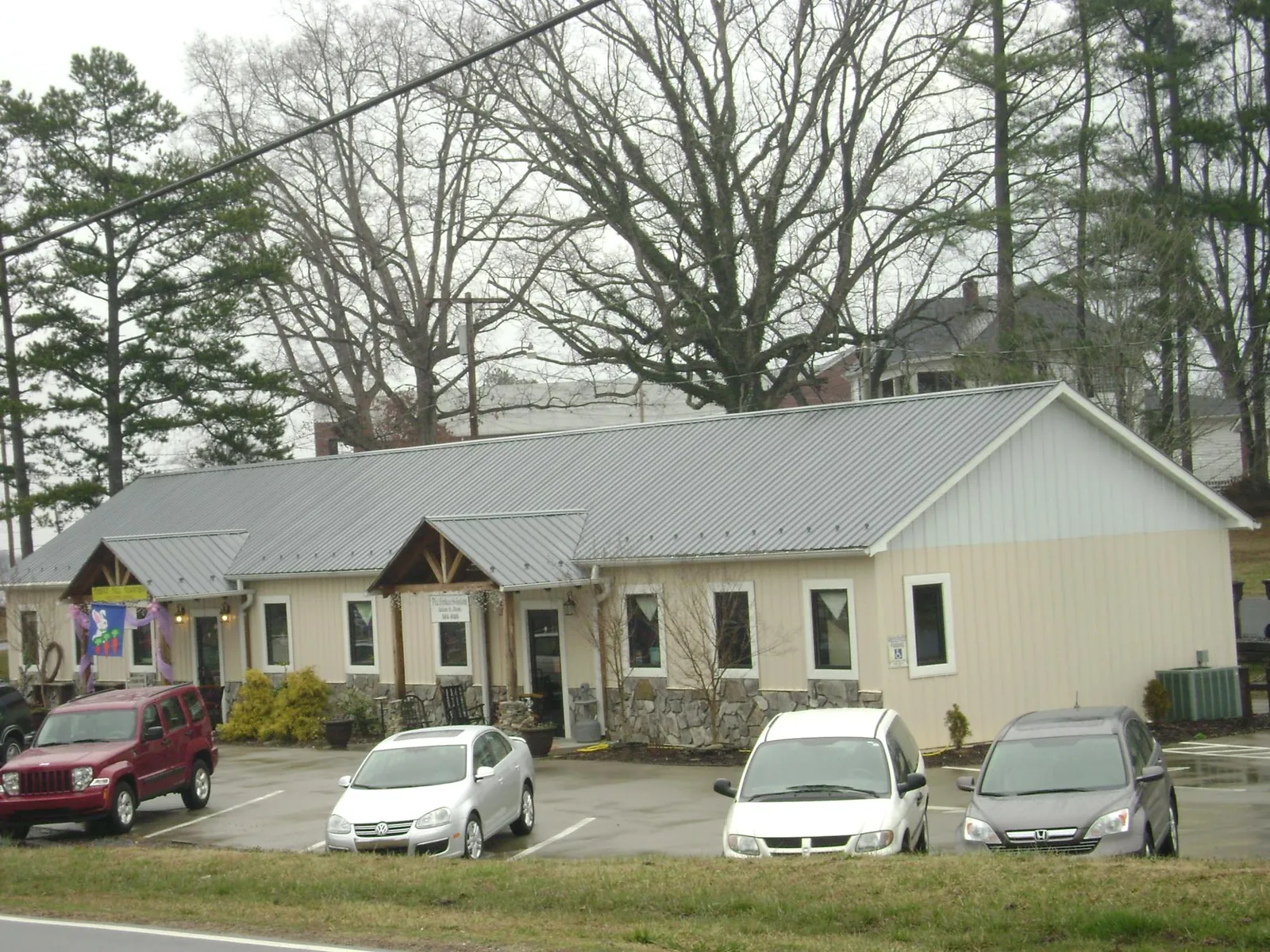 Gray metal roof with timber entry brackets on a small commercial building in Dillon